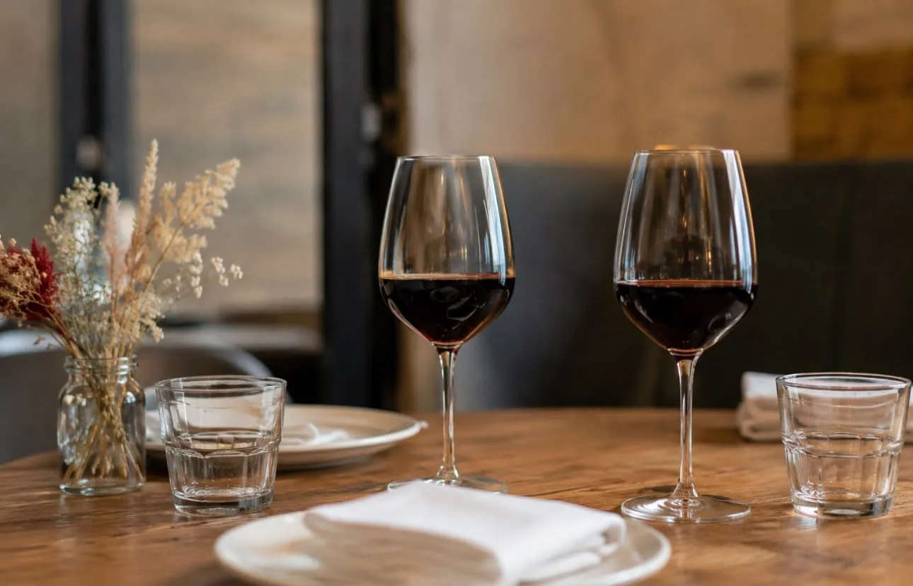 Deux verres de vin rouge sur une table en bois — restaurant du quartier Saint-Pierre à Bordeaux